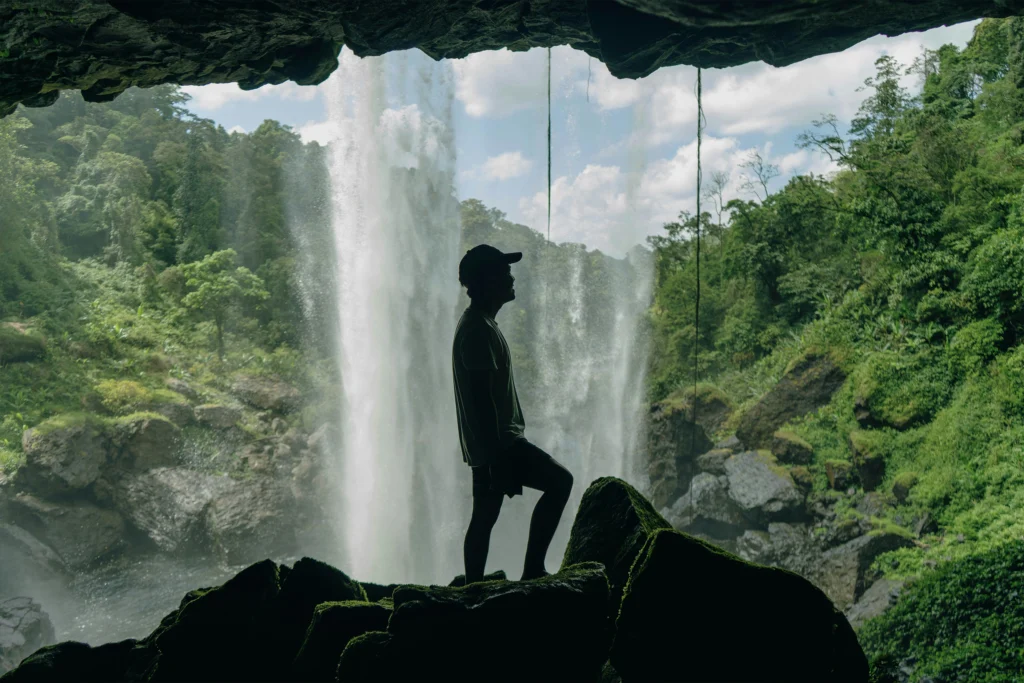 man standing in front of waterfall