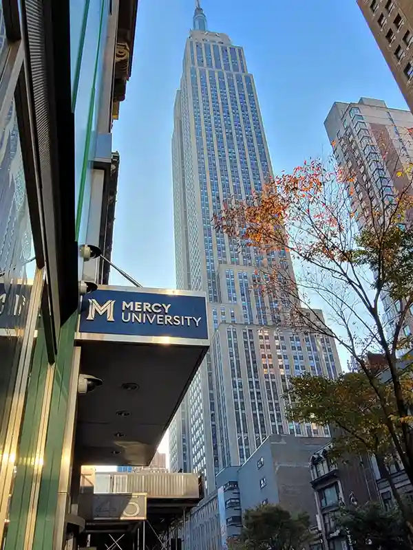 Mercy University Schild in Manhattan bei dem Empire State Building in New York.