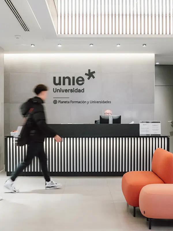 Empfangsbereich der UNIE Universidad in Madrid mit modernem Design und vorbeigehendem Studenten.