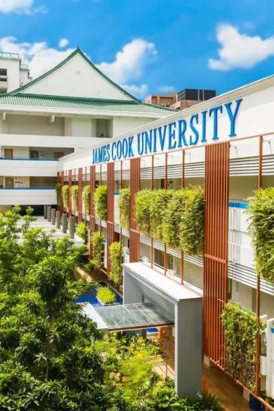 Außenansicht des James Cook University Campus in Singapur mit begrünten Fassaden und blauem Himmel